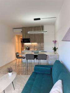 a living room with a blue couch and a kitchen at Central, quiet & cosy apartment near Monaco in Beaulieu-sur-Mer