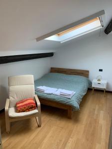 a bedroom with a bed and a chair and a skylight at Casa Angela Apartments in Bergamo