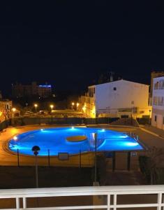 a large swimming pool at night with blue lights at sa caleta blava in Cala en Blanes