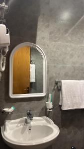 a bathroom with a sink and a mirror and towels at قمم بارك 3 Qimam Park Hotel in Abha