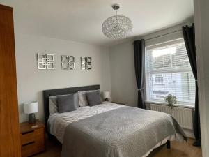 1 dormitorio con cama y lámpara de araña en The Haven in Hornsea Town Centre en Hornsea