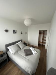 a bedroom with a bed with white sheets and pillows at Carpe diem in Strasbourg