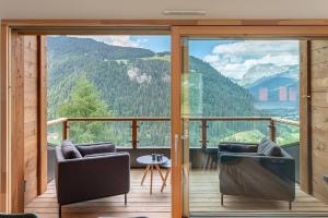 a balcony with two chairs and a view of a mountain at Chalet de Vonnes - Apt 10 - BO Immobilier in Châtel
