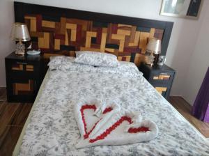 ein Schlafzimmer mit einem Bett mit zwei Herzen darauf in der Unterkunft Couple room in Final Destination Resort in Bolinao