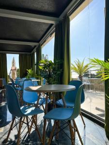 a restaurant with blue chairs and a table and windows at Hotel Medoviy in Gagra