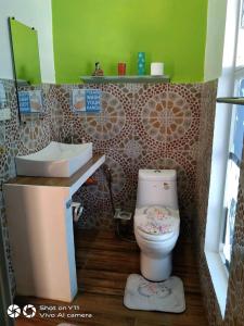 a bathroom with a toilet and a sink at Couple room in Final Destination Resort in Bolinao