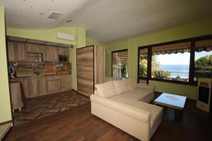 a living room with a couch and a kitchen at Hotel Continental in Kiten