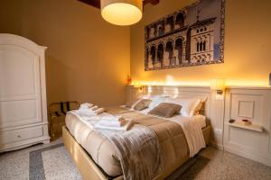 um quarto com uma cama grande e toalhas em Noble Floor - Luxury Apartments em Lucca