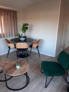 een kamer met een tafel en stoelen en een tafel en stoelen bij Gezellig chalet op een prachtige plek in Drenthe met vrij uitzicht in Tynaarlo