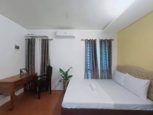 1 dormitorio con cama, escritorio y escritorio en 1 - Affordable Family Place to Stay In Cabanatuan, en Cabanatúan
