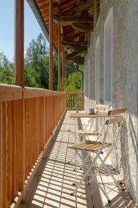 eine Holzterrasse mit einem Tisch und Stühlen darauf in der Unterkunft La Risorta in Cesiomaggiore