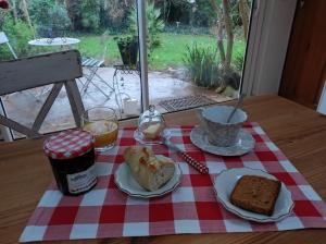 un tavolo con una tovaglia a scacchi rossa e bianca con sopra del cibo di Chambres d'hôtes de charme sur LE MANS a Le Mans