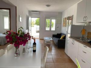 a kitchen and living room with a table with a bottle of wine at Modern and airy holiday home in Torrevieja