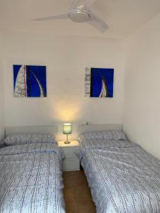 two beds in a room with paintings on the wall at Modern and airy holiday home in Torrevieja