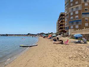 uma praia com cadeiras e guarda-sóis e pessoas nela em Modern and airy holiday home em Torrevieja