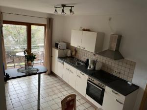 a kitchen with a sink and a stove top oven at Die Ferienwohnungen Dominik , Fill in Horath