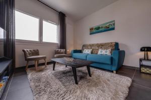 a living room with a blue couch and a table at Le 305 - T3 with garage and beautiful terrace in Annecy