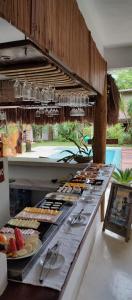 una línea de buffet con muchos tipos diferentes de comida en Pousada Raízes do Brasil, en Trancoso