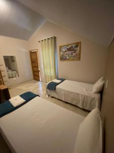 a hotel room with two beds and a mirror at Pousada Beira da Mata-Jalapão in Mateiros