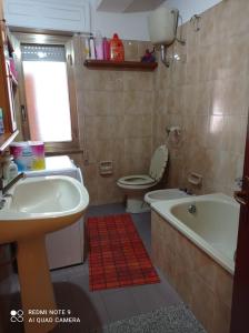 een badkamer met een wastafel, een toilet en een bad bij bandiera blu in Marina di Gioiosa Ionica