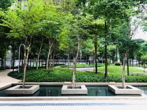 een fontein in een park met bomen en water bij 2BR Apartment @ Icon City in Petaling Jaya