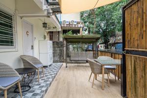 eine Terrasse mit Stühlen, einem Tisch und einem Kühlschrank in der Unterkunft Canal View Lo-ha guest house, Contactless Check-in in Bangkok