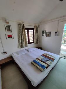 a large bed in a room with a window at Osaree Agro and Art Hub in Kolhapur