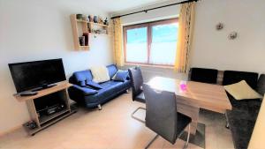 ein Wohnzimmer mit einem Tisch und einem blauen Sofa in der Unterkunft Schernthaner in Taxenbach