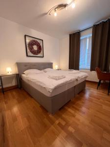 a bedroom with a large bed and a wooden floor at Jalda Apartments in Düsseldorf