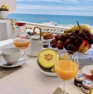 - une table avec une assiette de fruits et une boisson dans l'établissement Albufeira Holidays Penthouse Sea View, à Albufeira