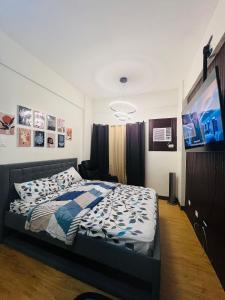 - une chambre avec un lit et une télévision dans l'établissement Condo Staycation at Valenzuela I Studio type, à Manille