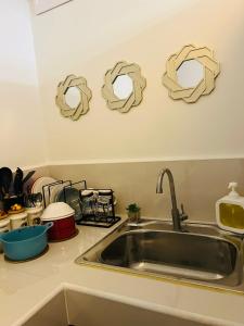 - un comptoir de cuisine avec évier et quelques rouleaux de papier sur le mur dans l'établissement Condo Staycation at Valenzuela I Studio type, à Manille