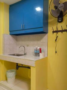 a kitchen with a sink and a blue cabinet at YellowPad Hotel (SM-Eco) in Davao City +19 photos