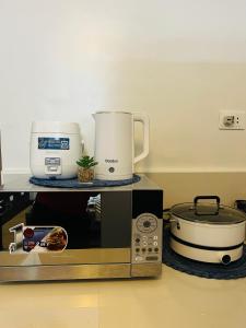 a microwave with a slow cooker and a slow cooker at Condo Staycation at Valenzuela I Studio type in Manila