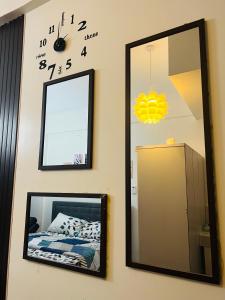 a mirror and a clock on a wall with a bed at Condo Staycation at Valenzuela I Studio type in Manila
