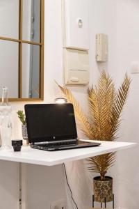 a laptop computer sitting on a white desk at Studio cosy au coeur de l'Ecusson - Arènes à 2 min in Nîmes