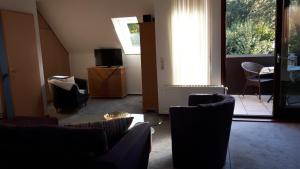 sala de estar con sillas, mesa y TV en Ferienwohnung Steingraf, en Cuxhaven