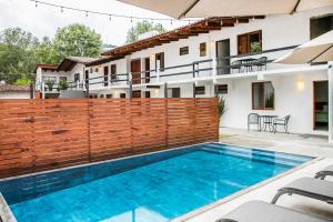 a house with a swimming pool and a wooden fence at Villa Maria Hotel in Valle de Bravo