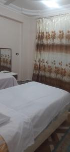 a bedroom with a white bed and a curtain at apartment for rent in Luxor