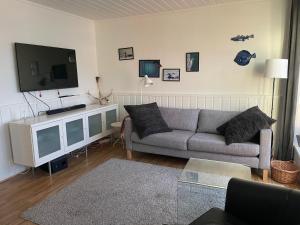 a living room with a couch and a flat screen tv at Spacious apartment with view over the trondheimfjord in Vangshylla