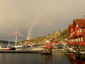 a rainbow over a marina with boats and houses at Spacious apartment with view over the trondheimfjord in Vangshylla