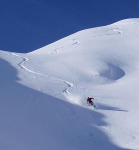 a person is skiing down a snow covered mountain at appartement ski au pied in Valmorel