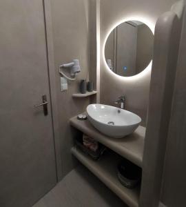 a bathroom with a sink and a mirror at Enigma Boutique Houses Votsalo in Marmarion