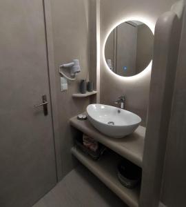 łazienka z umywalką i lustrem w obiekcie Enigma Boutique Houses Votsalo w mieście Marmari +37 zdjęć
