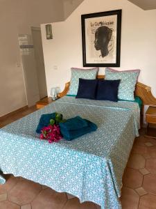 a bed with blue pillows and flowers on it at Villa Les Nereides in Le Moule