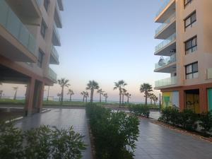 un complejo de apartamentos con palmeras a lo lejos en portosaid resort منتجع بورتوسعيد شاليه ارضي مع جاردن, en Puerto Saíd