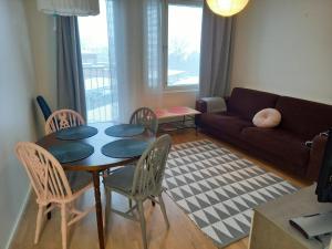 een woonkamer met een tafel en stoelen en een bank bij New&Easy apartment in the center in Turku