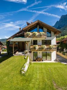 ein Haus in den Bergen mit grünem Rasen in der Unterkunft Appartments Simone in Ehrwald