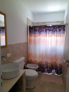 a bathroom with a toilet and a shower curtain at Casas Tomillo Silvestre in Sierra de la Ventana
