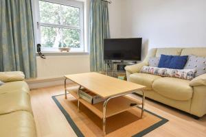 a living room with a couch and a coffee table at 12A Solent Landing direct beach access in Bembridge